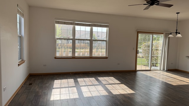 empty room with ceiling fan, dark hardwood / wood-style flooring, and a healthy amount of sunlight