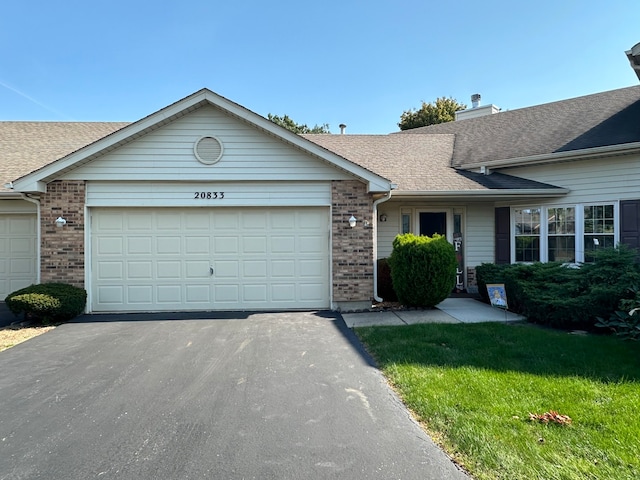 single story home featuring a front yard and a garage