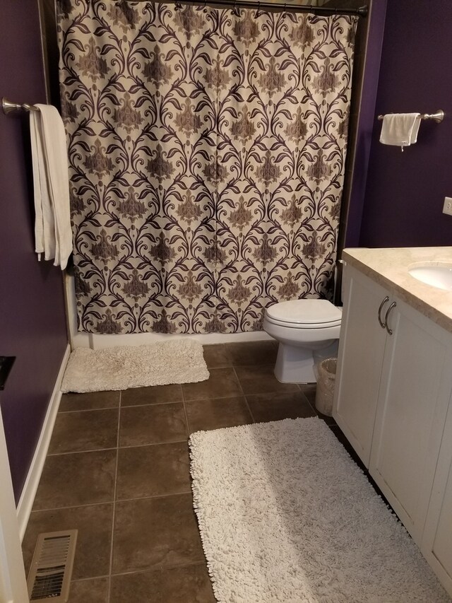 bathroom featuring a shower, tile patterned flooring, vanity, and toilet