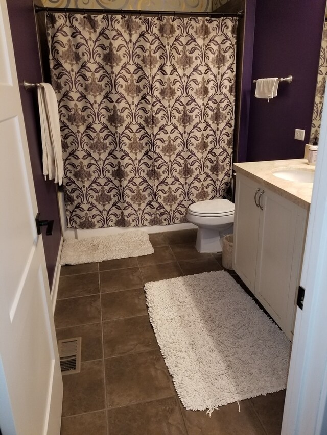 bathroom featuring walk in shower, tile patterned flooring, vanity, and toilet