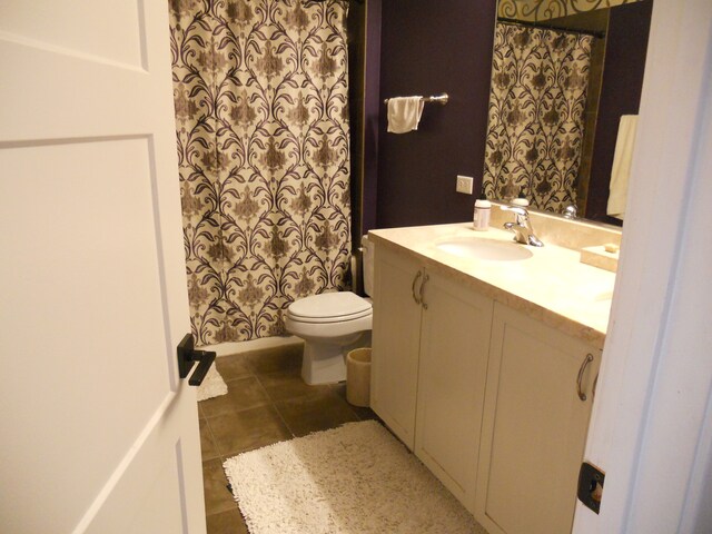 bathroom with tile patterned flooring, vanity, and toilet