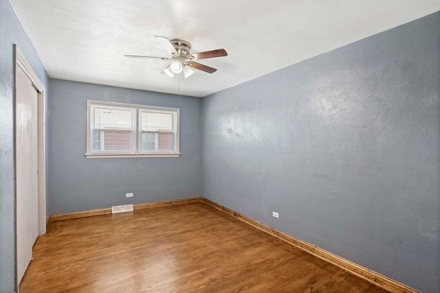 unfurnished bedroom with ceiling fan, a closet, and hardwood / wood-style floors