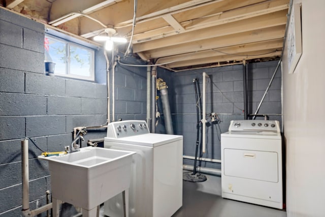 clothes washing area with washing machine and dryer and sink