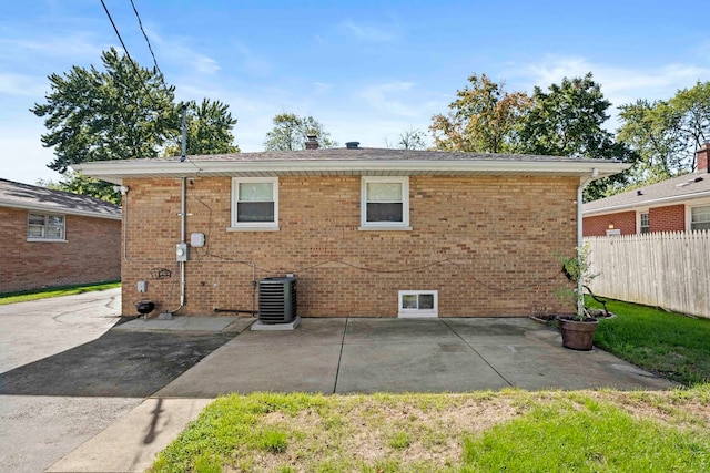 rear view of property with cooling unit and a patio area