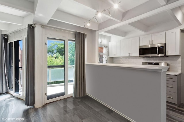 kitchen with kitchen peninsula, backsplash, sink, white cabinets, and dark hardwood / wood-style floors