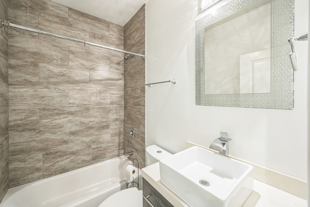 full bathroom featuring vanity, tiled shower / bath combo, and toilet