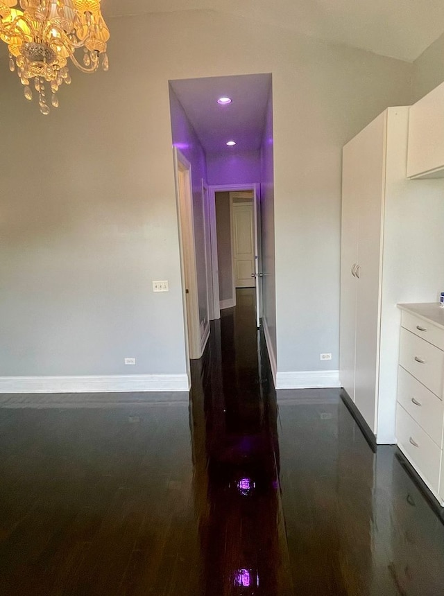 hallway featuring a chandelier and dark hardwood / wood-style floors