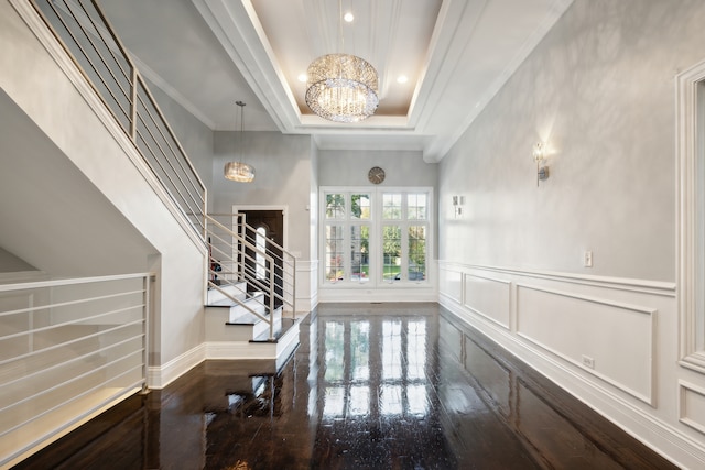 interior space featuring a raised ceiling, a wealth of natural light, hardwood / wood-style flooring, and a notable chandelier