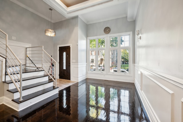 foyer entrance featuring a high ceiling, ornamental molding, and hardwood / wood-style floors