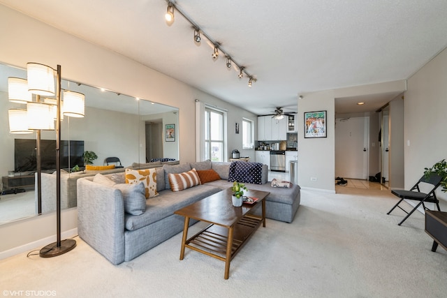 living room featuring ceiling fan, track lighting, and light carpet