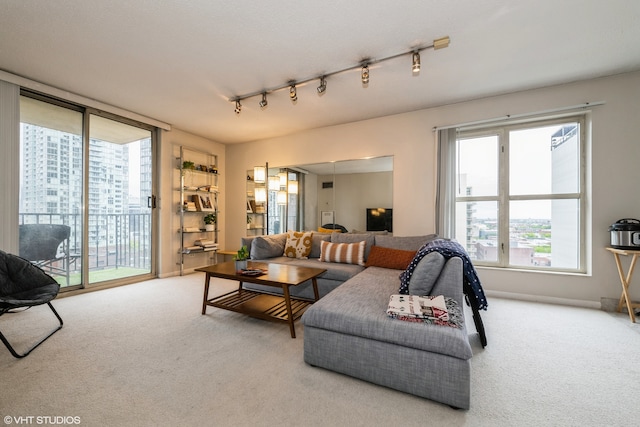 living room featuring light carpet, track lighting, and a wealth of natural light