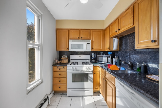 kitchen with a healthy amount of sunlight, sink, white appliances, and light tile patterned floors