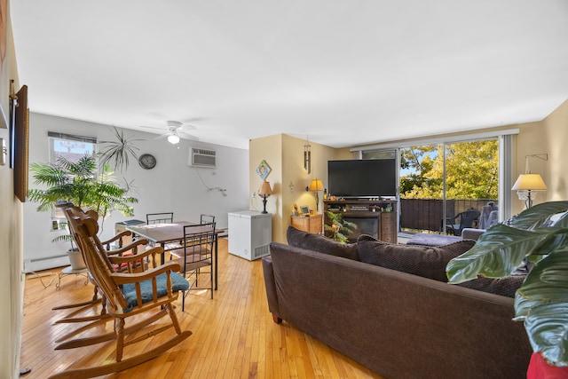 living room with light hardwood / wood-style floors, a wall mounted AC, a baseboard radiator, and ceiling fan