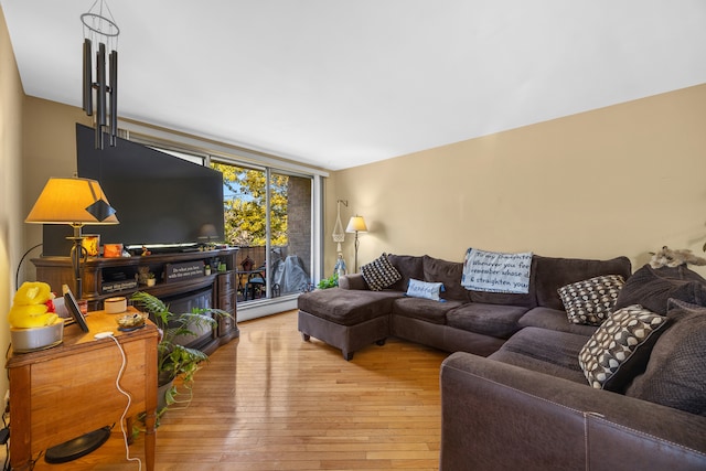 living room featuring baseboard heating, light wood-type flooring, and a fireplace