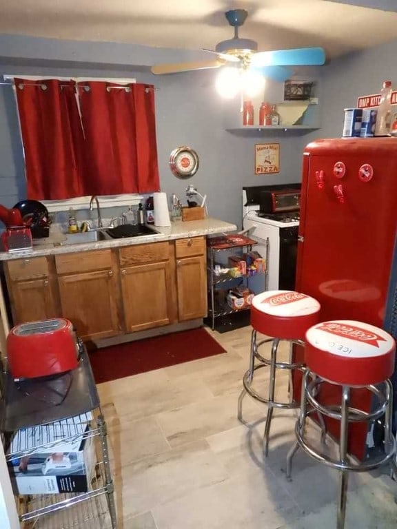 kitchen featuring fridge, sink, and ceiling fan