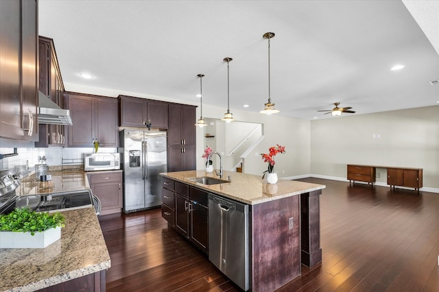 kitchen featuring a center island with sink, pendant lighting, dark wood-type flooring, and appliances with stainless steel finishes