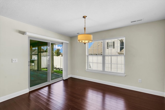 spare room with dark hardwood / wood-style flooring and a textured ceiling