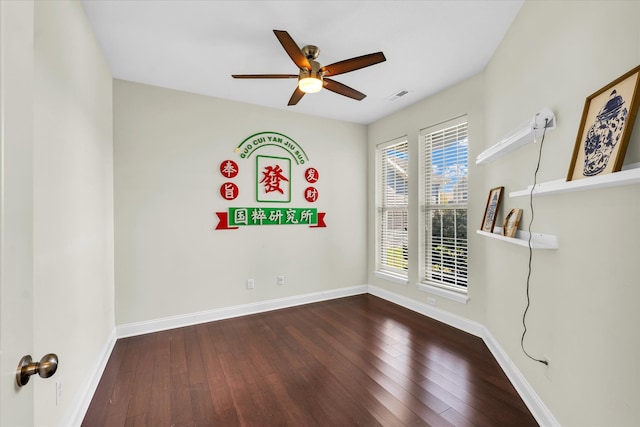 empty room with ceiling fan and dark hardwood / wood-style floors