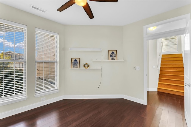 spare room with ceiling fan, dark wood-type flooring, and a wealth of natural light