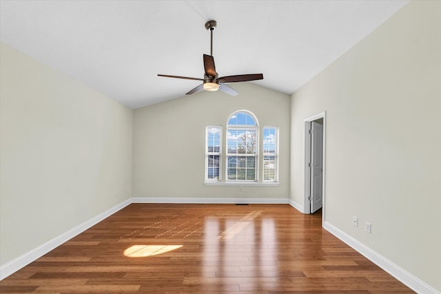 spare room with ceiling fan, vaulted ceiling, and wood-type flooring