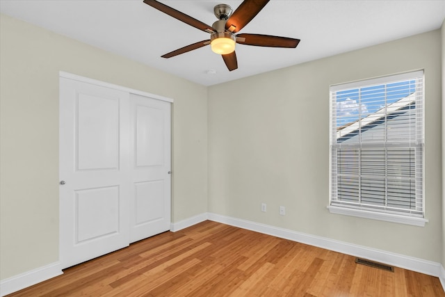 unfurnished bedroom featuring ceiling fan, a closet, and light hardwood / wood-style floors