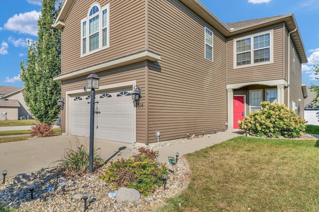 view of side of home with a yard and a garage