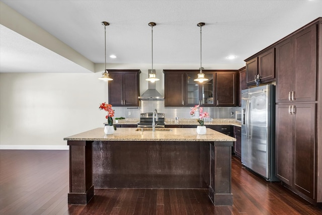 kitchen featuring dark wood-type flooring, wall chimney range hood, and appliances with stainless steel finishes