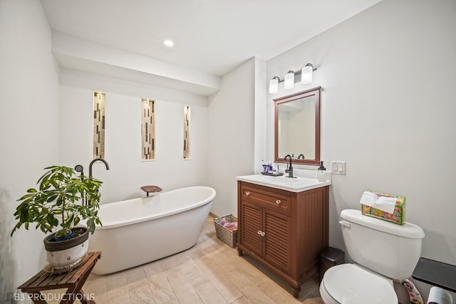 bathroom featuring vanity, a tub to relax in, toilet, and wood-type flooring