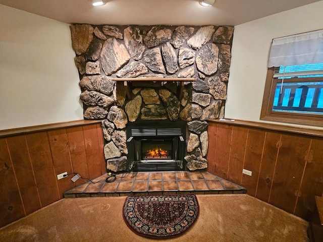 interior details with wood walls, a fireplace, and carpet floors