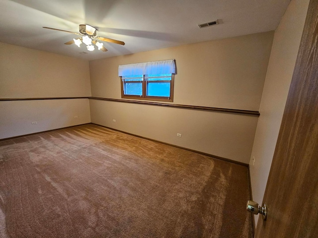 carpeted spare room featuring ceiling fan