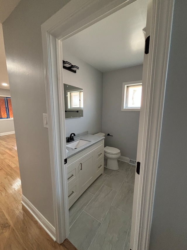 bathroom featuring hardwood / wood-style flooring, vanity, and toilet