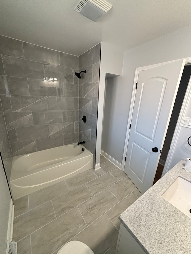 full bathroom with toilet, vanity, and tiled shower / bath