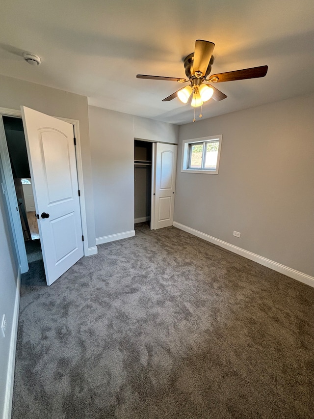 unfurnished bedroom featuring ceiling fan, a closet, and dark colored carpet