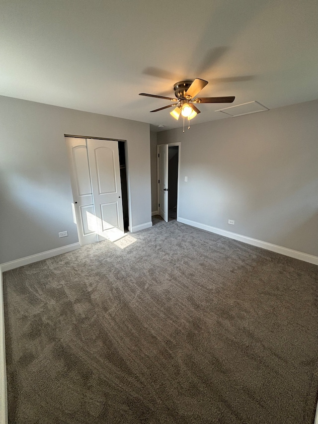 unfurnished bedroom with ceiling fan, a closet, and dark colored carpet