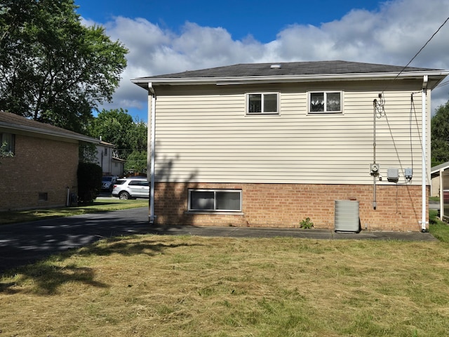 view of side of property featuring a yard and central air condition unit