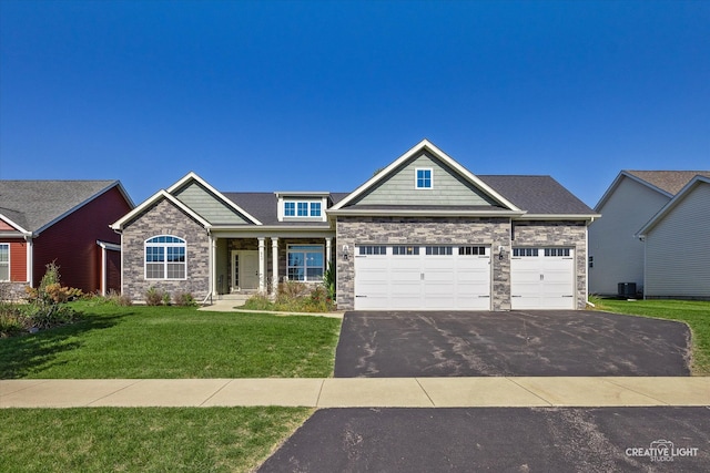 craftsman inspired home with a garage, a front lawn, and central AC unit