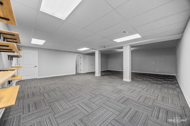 basement featuring a drop ceiling and carpet flooring