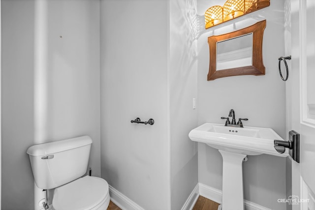 bathroom featuring hardwood / wood-style floors and toilet