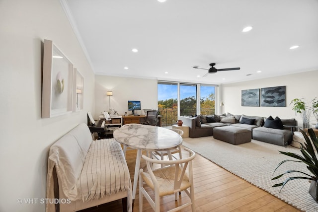 living room with hardwood / wood-style floors, ceiling fan, expansive windows, and crown molding