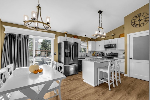 4661 W Tulip Ave, Monee, IL 60449 - kitchen with black appliances, a chandelier, a sink, a kitchen island, and tasteful backsplash