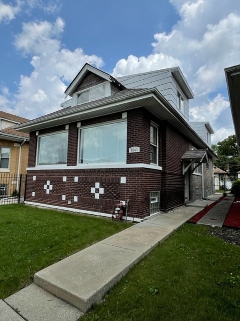 view of side of home with a yard