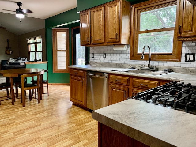 kitchen featuring ceiling fan, dishwasher, backsplash, and light hardwood / wood-style floors