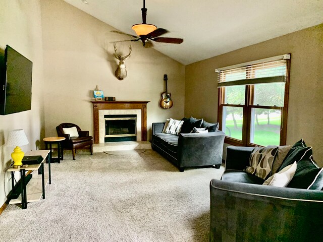 living room featuring carpet floors, ceiling fan, vaulted ceiling, and a tile fireplace