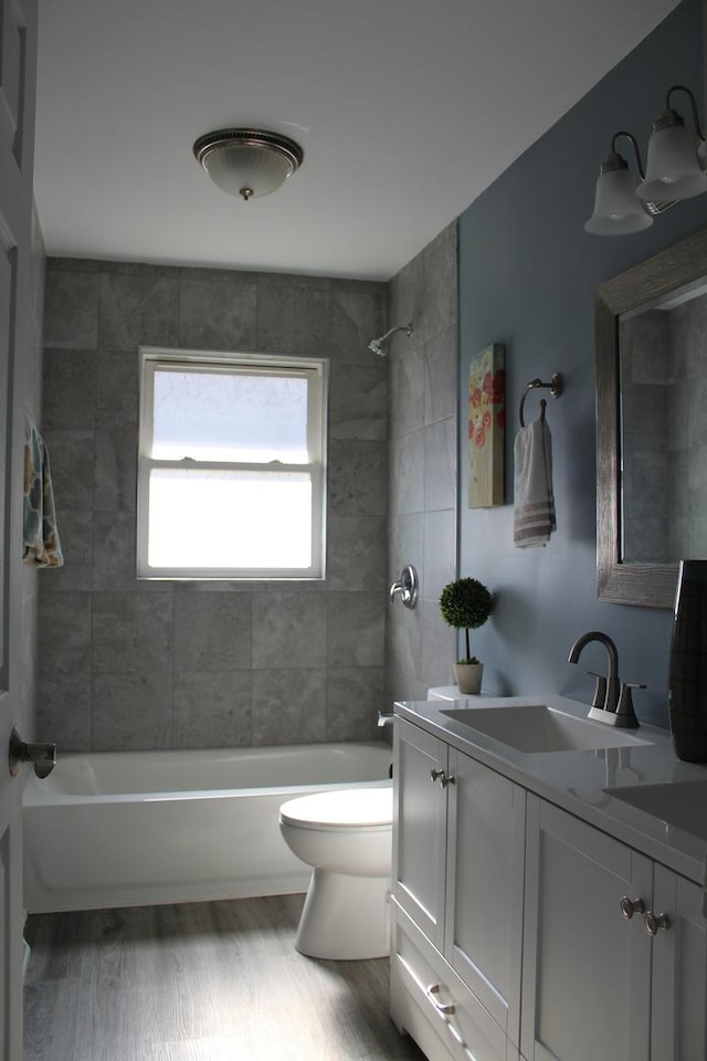 full bathroom with wood-type flooring, vanity, toilet, and tiled shower / bath