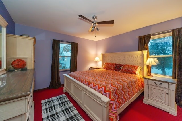 carpeted bedroom featuring multiple windows and ceiling fan