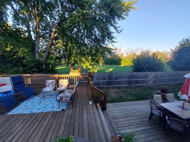 wooden deck featuring a lawn