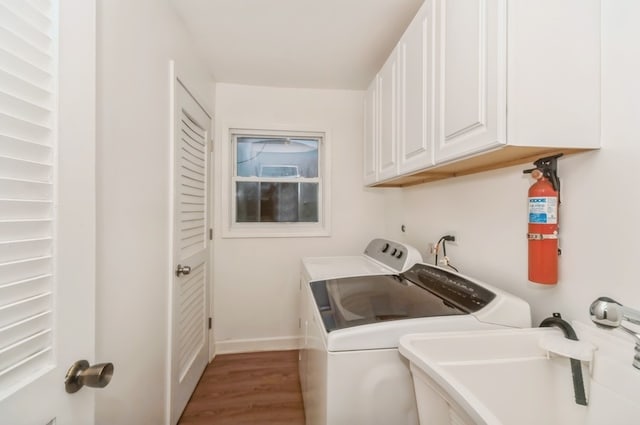 washroom featuring washer and clothes dryer, dark hardwood / wood-style floors, cabinets, and sink