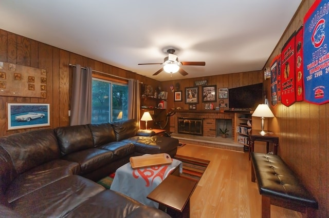 living room with wooden walls, ceiling fan, and hardwood / wood-style flooring