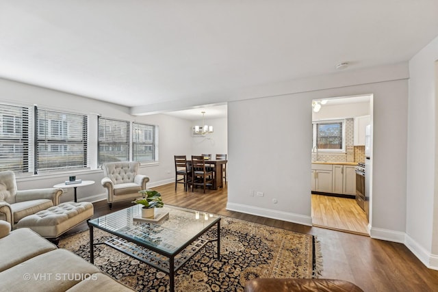 living room featuring a chandelier and light hardwood / wood-style flooring