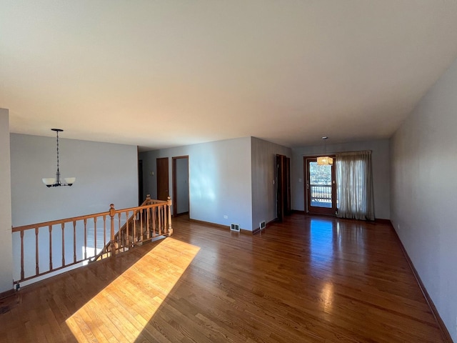 unfurnished room with dark hardwood / wood-style flooring and a chandelier